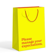 Yellow lime medium gift bag with red slogan text on white background.