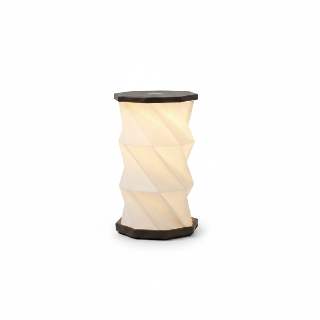 Twisted cylindrical lamp and wooden speaker on a light gray background