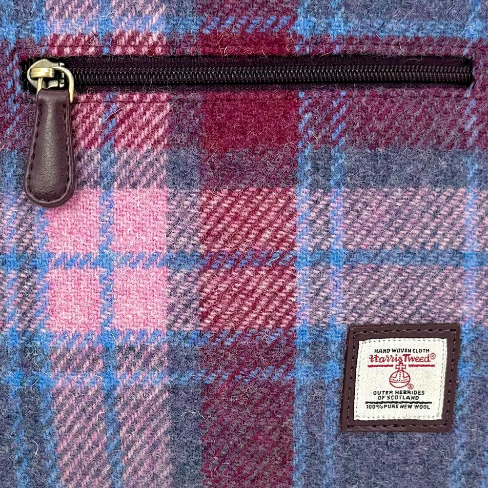 Close-up of pastel pink Harris Tweed plaid texture and label.