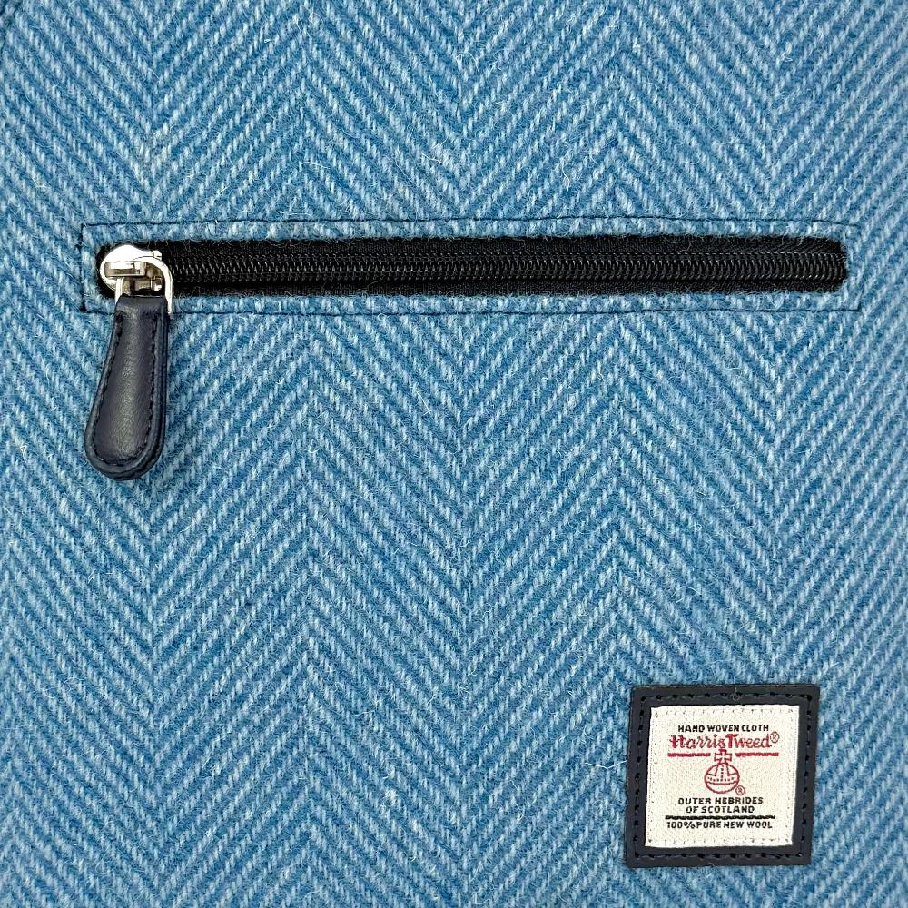 Close-up of sky blue Harris Tweed herringbone texture and label.