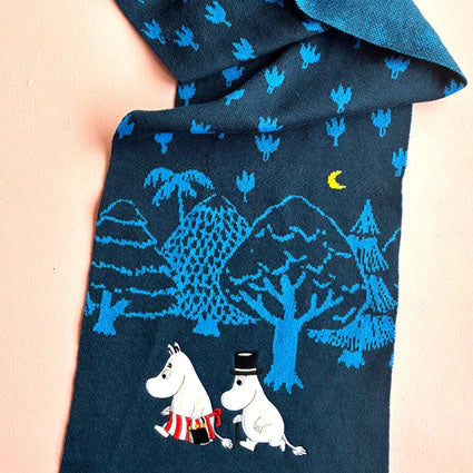 Close-up of Moomin Blue Forest Embroidered Scarf showing Moomin characters and moonlit trees on blue knit fabric.