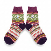 Flat lay of colourful Fair Isle Moomin Snorkmaiden socks on white background.