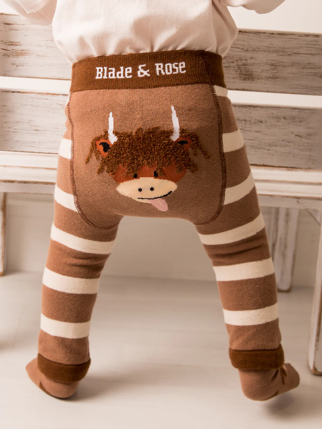 Toddler standing in Neutral Highland Cow Leggings with fluffy Hamish Highland Cow design.