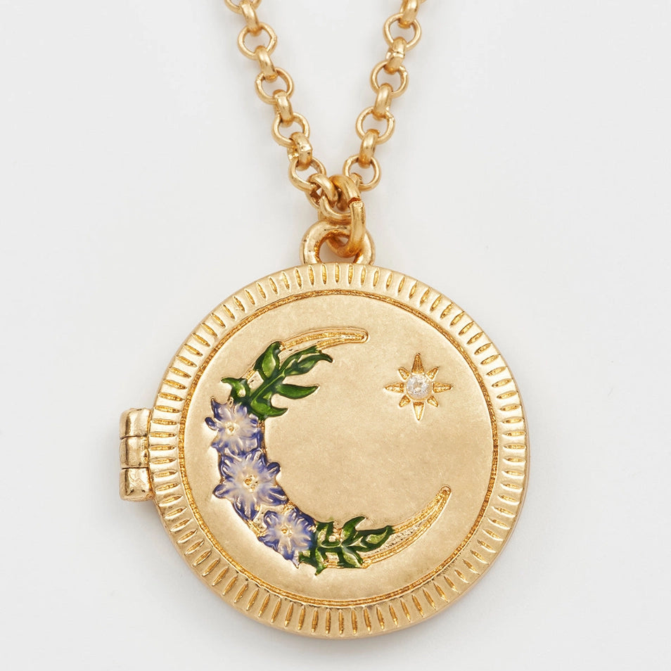 Close-up of Nightshade Moon Round Gold Locket with enamel flowers and cubic zirconia moon.