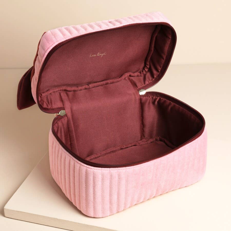 Open velvet makeup bag showing spacious burgundy-lined interior.