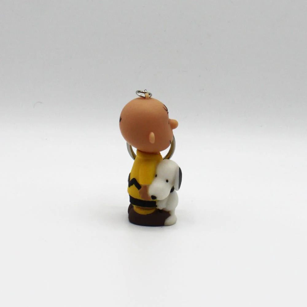 Charlie Brown & Snoopy keyring lying down, showing the button that activates the light.