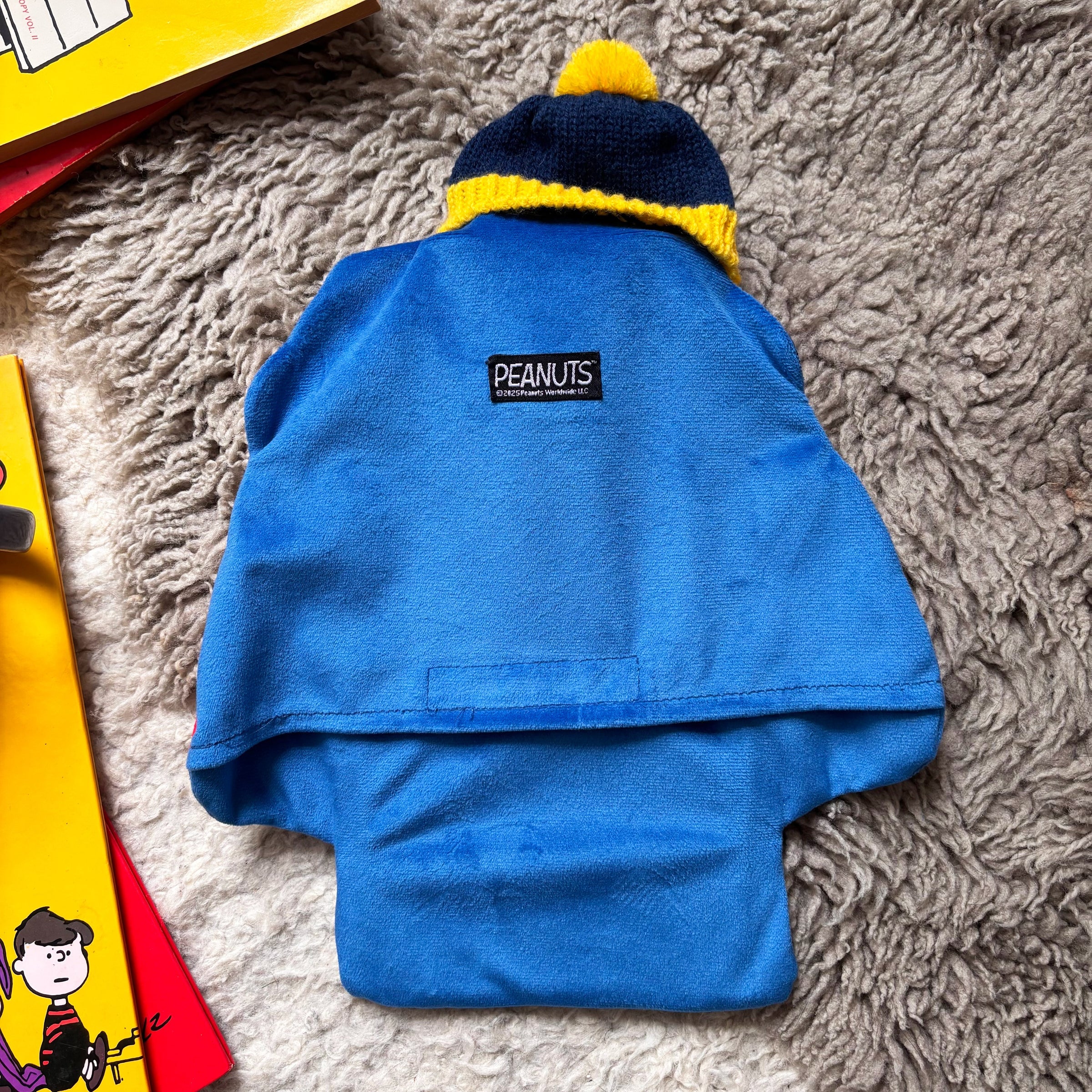 Back view of Peanuts Snoopy Puffa Hot Water Bottle with blue velour fabric and Peanuts label.