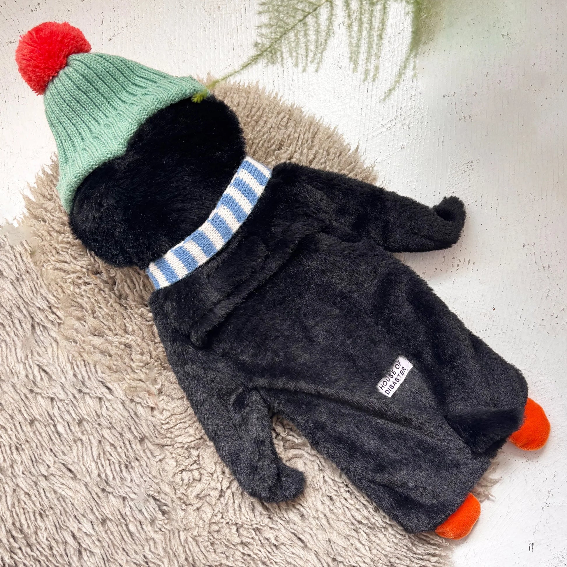 Back view of penguin hot water bottle showing soft plush cover.