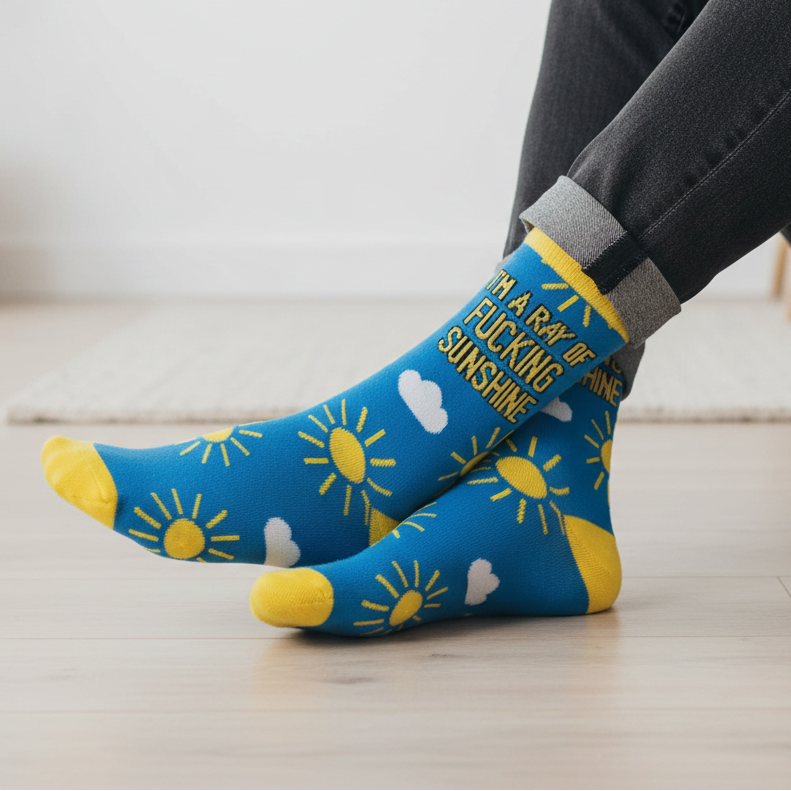 Man wearing blue and yellow socks that say "I am a ray of fucking sunshine".
