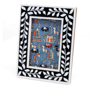 Front angled view of navy blue resin picture frame with white leaf border and decorative insert.