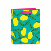 Small recyclable lemon gift bag with Anne Bentley’s bold yellow fruit and green leaf illustrations on a turquoise background, featuring pink grosgrain ribbon handles and a matching gift tag.