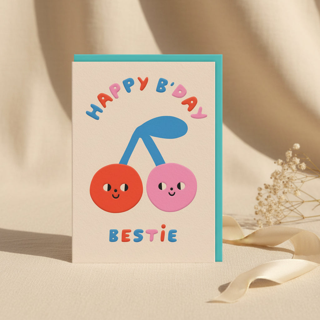 Birthday card with two smiling cherries and 'Happy B'day Bestie' text on a beige background.