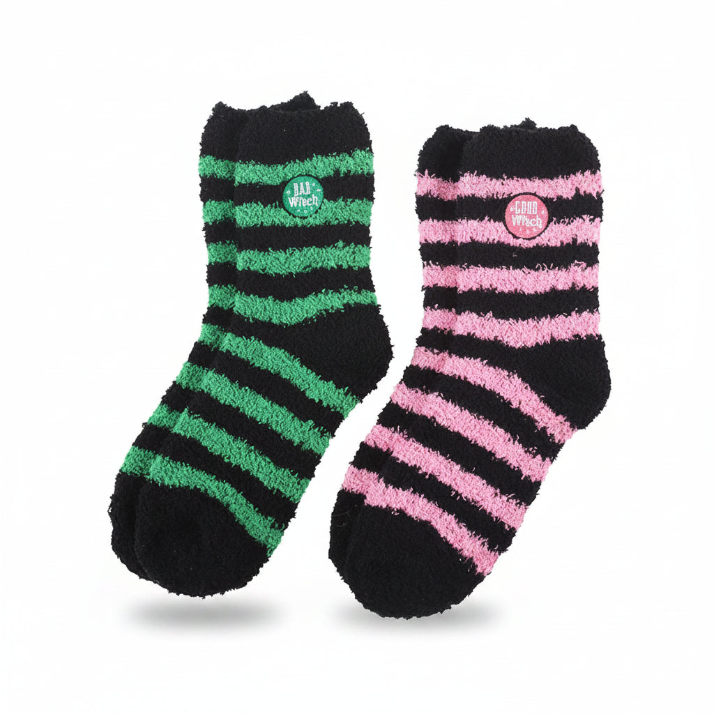 Green and pink striped witch-themed fluffy socks laid flat – Good Witch and Bad Witch design.