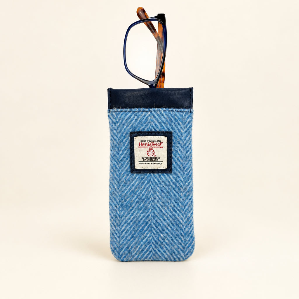 Glasses peeking out from the top of a Harris Tweed sleeve in herringbone sky blue fabric.