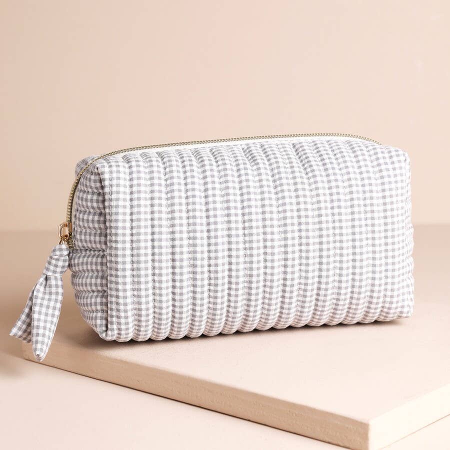 Grey and white gingham travel bag with gold zip displayed on neutral background.