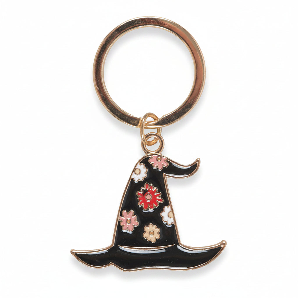 Floral enamel witch hat keyring showing gold detailing and pastel flowers
