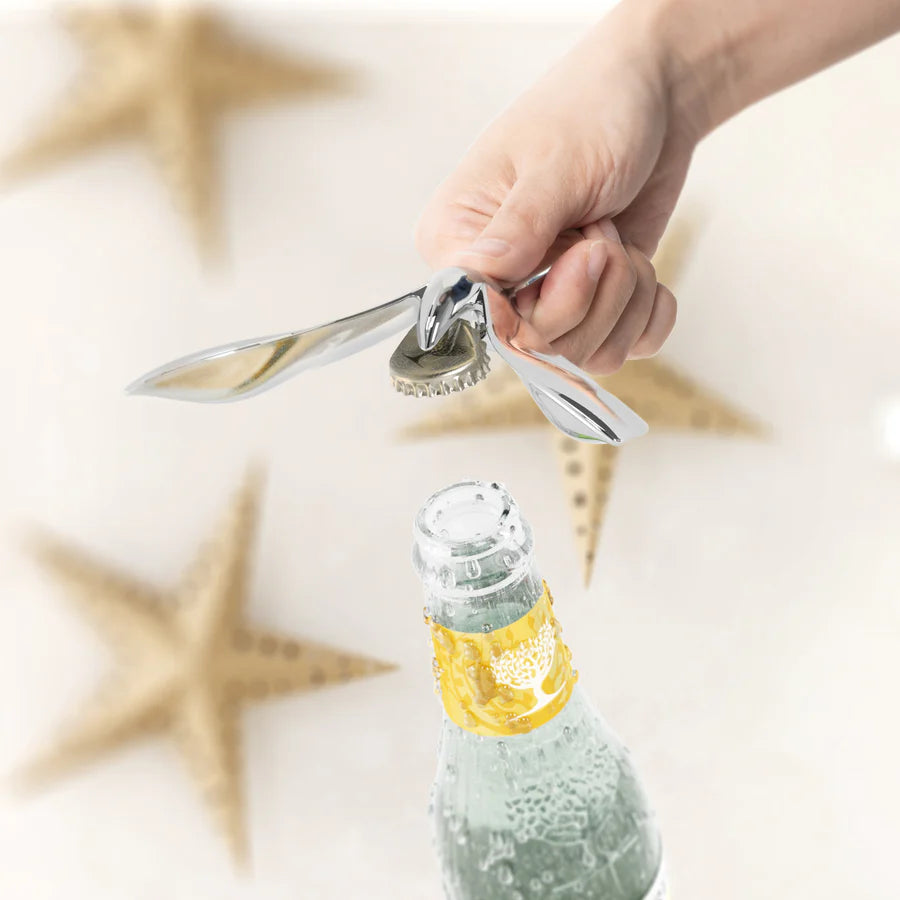 Hand using Umbra Tipsy opener to pop a bottle cap close-up action