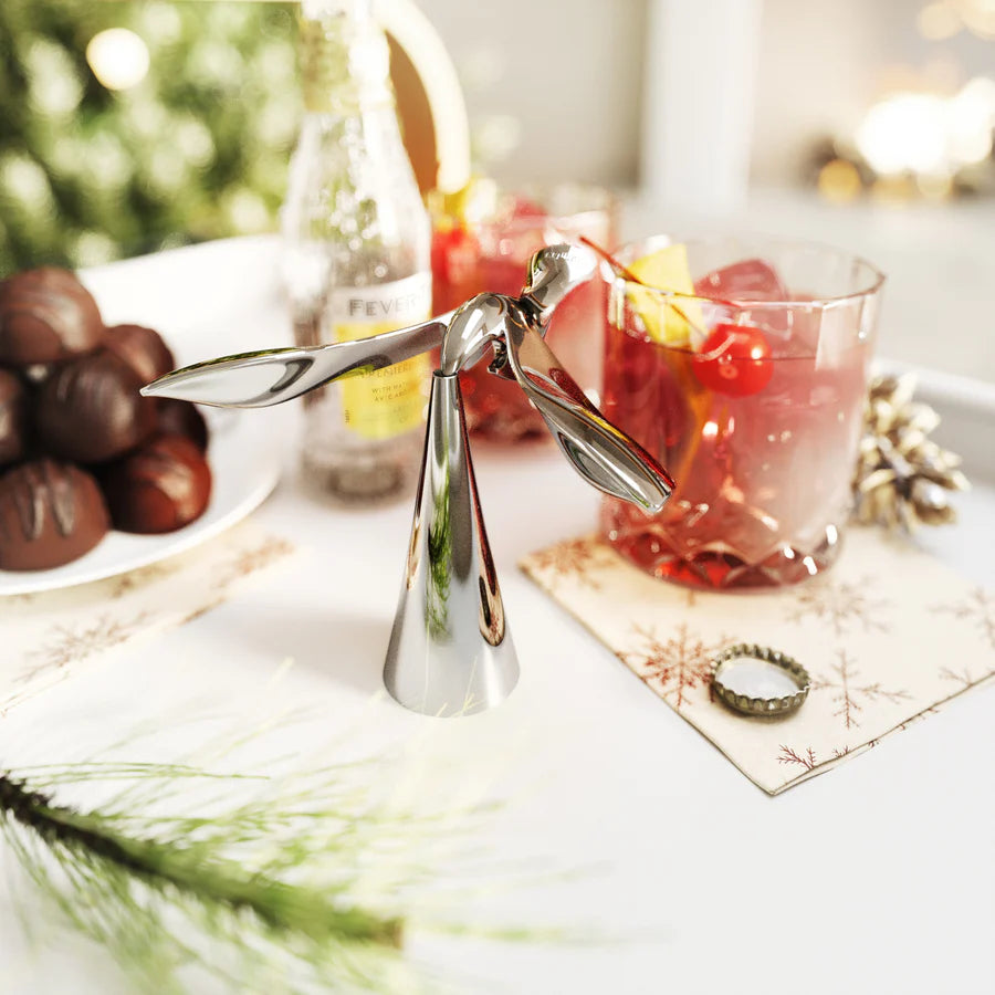 Tipsy bottle opener chrome on festive table with food and cocktails