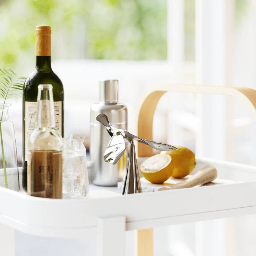 Umbra Tipsy opener chrome on counter with wine bottle and chopping board