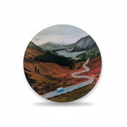 Close-up of the Up the Highlands vinyl sticker showing a scenic gouache illustration of a camper van driving along a winding road through the Scottish Highlands.
