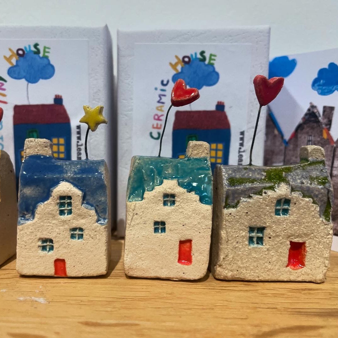 Close-up of unique miniature ceramic houses in various colours and shapes, handmade in Scotland.