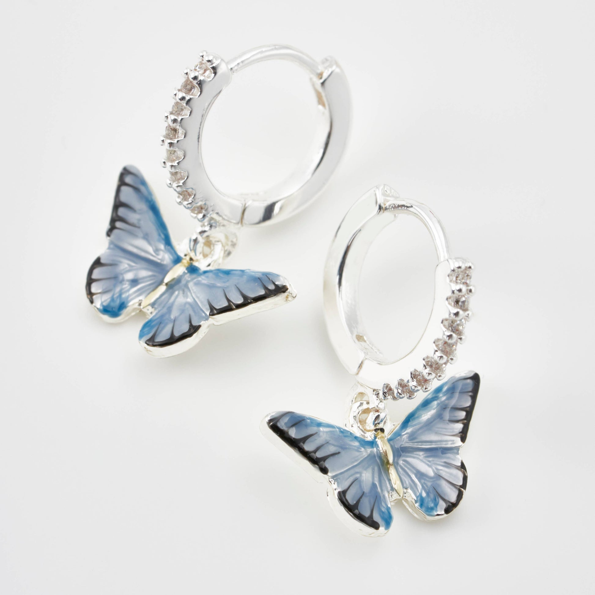 Pair of blue enamel butterfly earrings on white background