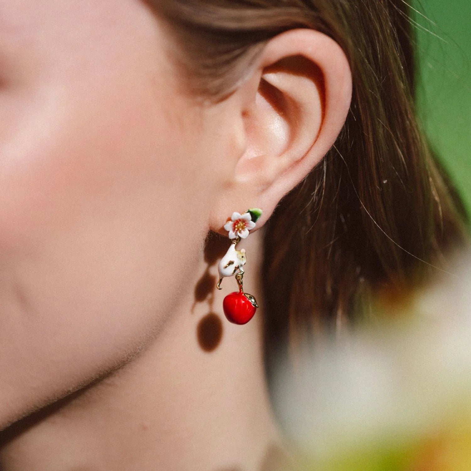 Side view of woman wearing Apple Blossom & Mouse Drop Earrings with red apple charm.