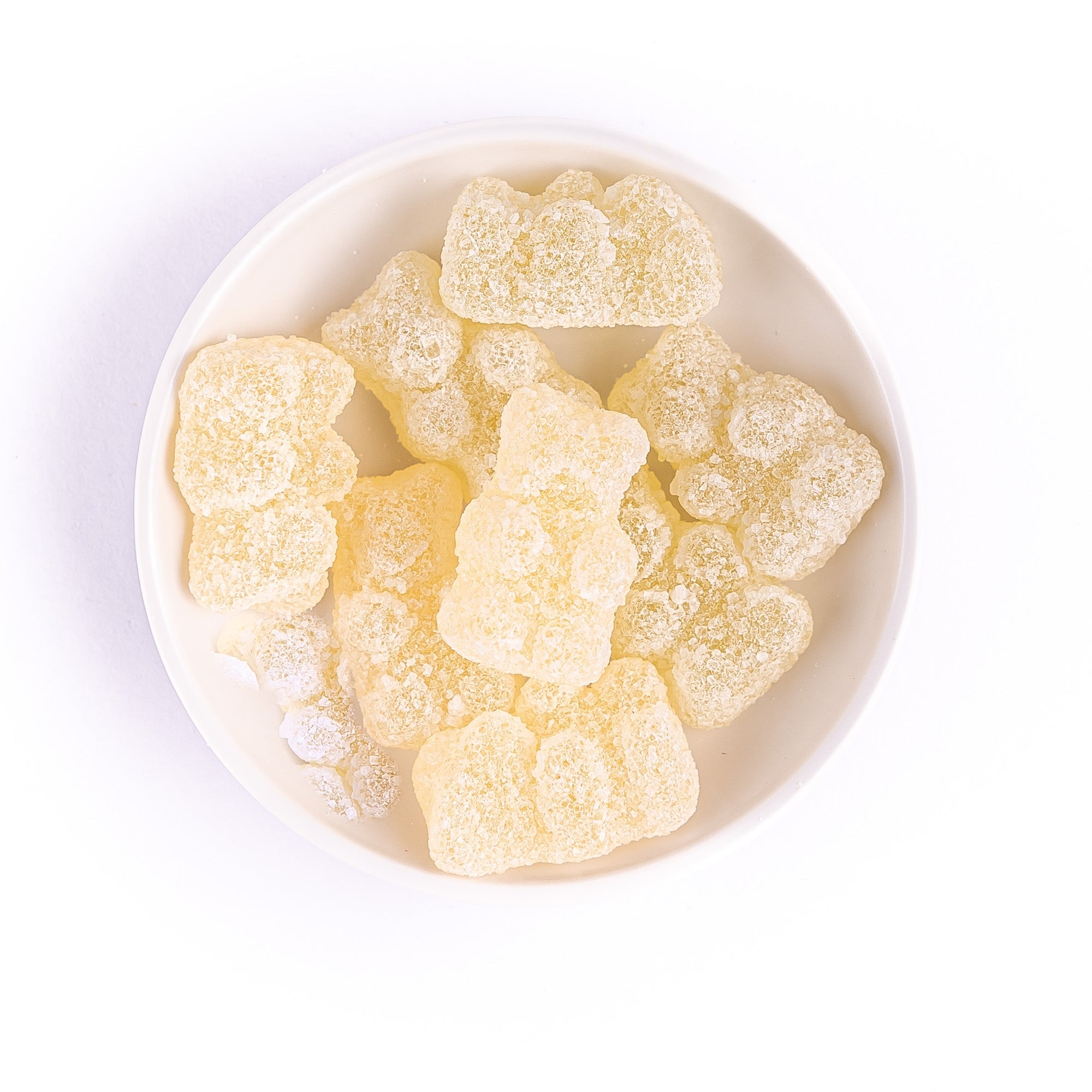 Gin Fizz gummy bears piled in a white bowl, close-up