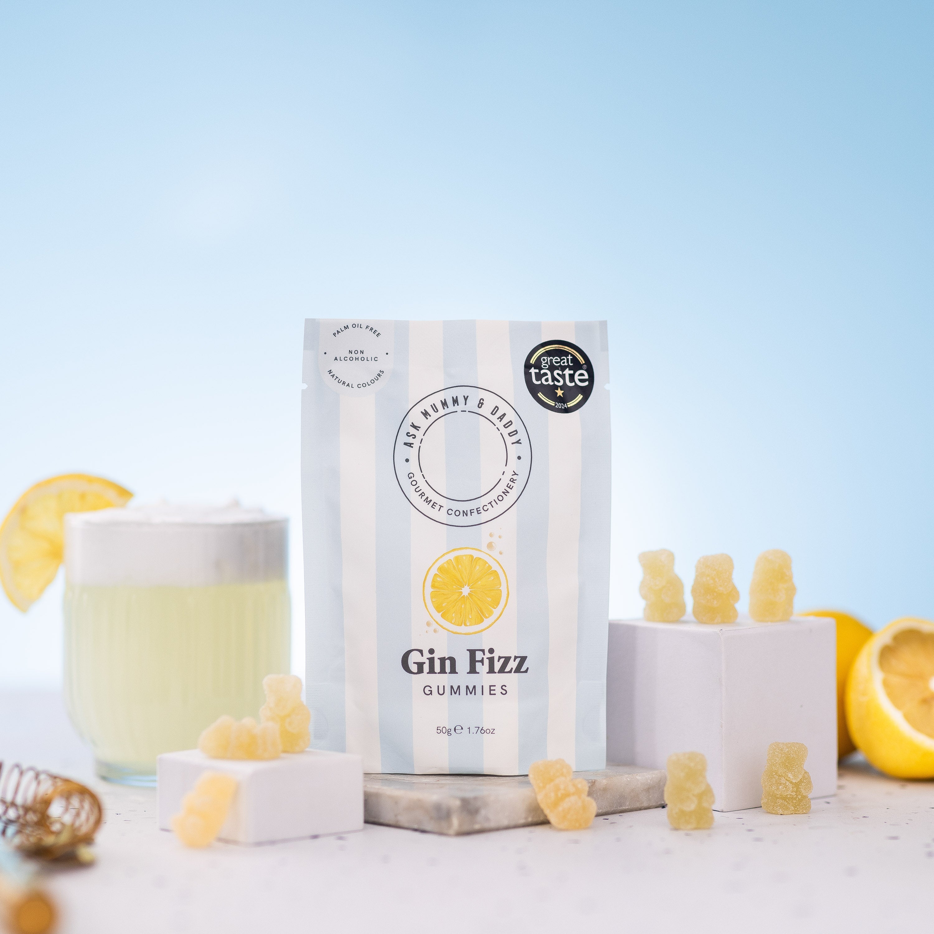 Gin Fizz Gummies pouch displayed with a citrus mocktail, lemon and gummy bears