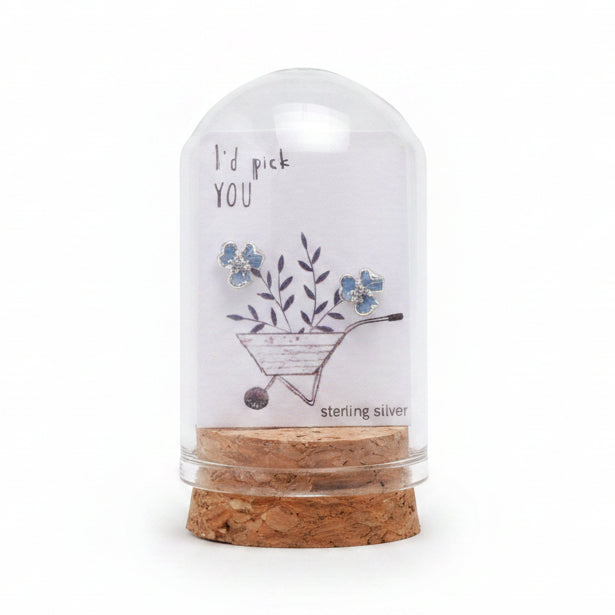 Blue three-petal flower earrings on message card inside glass terrarium held in hand