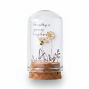 Glass terrarium with friendship card and gold bee and flower earrings held in hand