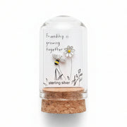 Silver bee and flower friendship earrings on card inside glass terrarium held in hand