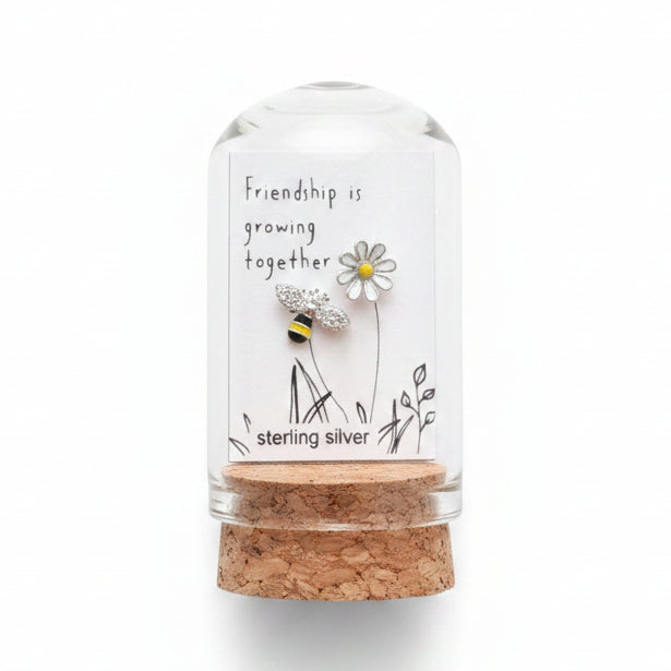 Silver bee and flower friendship earrings on card inside glass terrarium held in hand