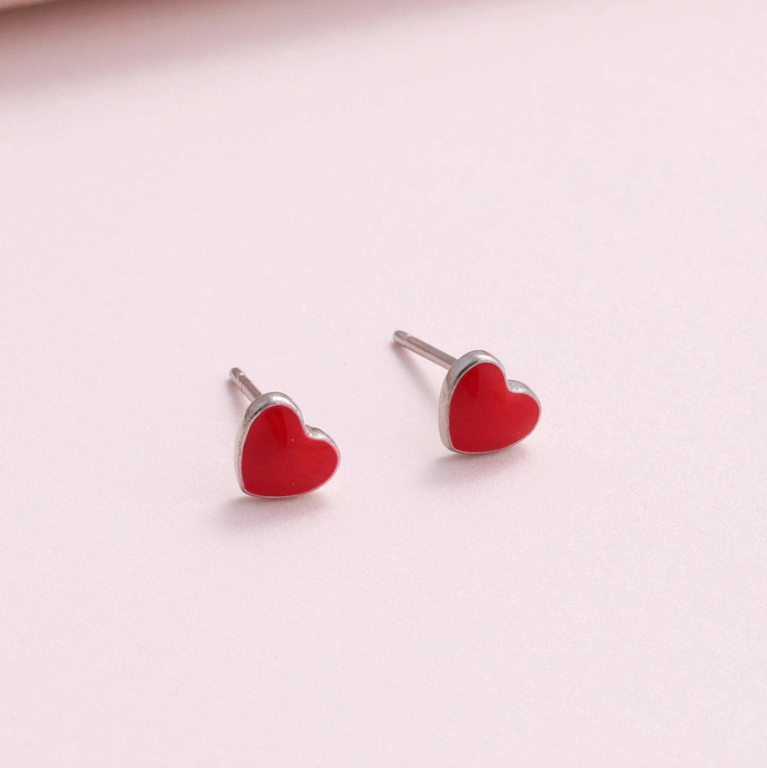 Two red enamel heart stud earrings close-up on white background