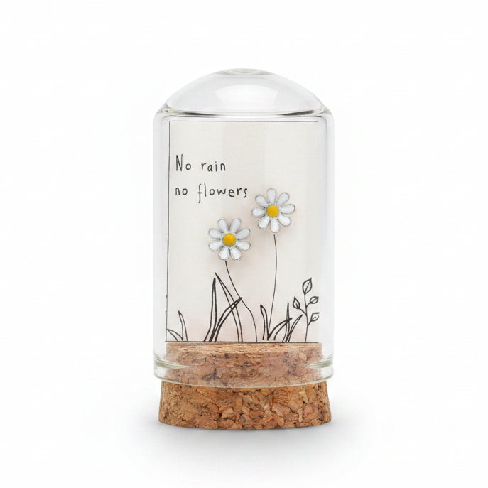 Silver enamel daisy earrings on message card inside glass terrarium held in hand