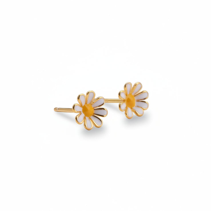 Two gold daisy stud earrings close-up on light background