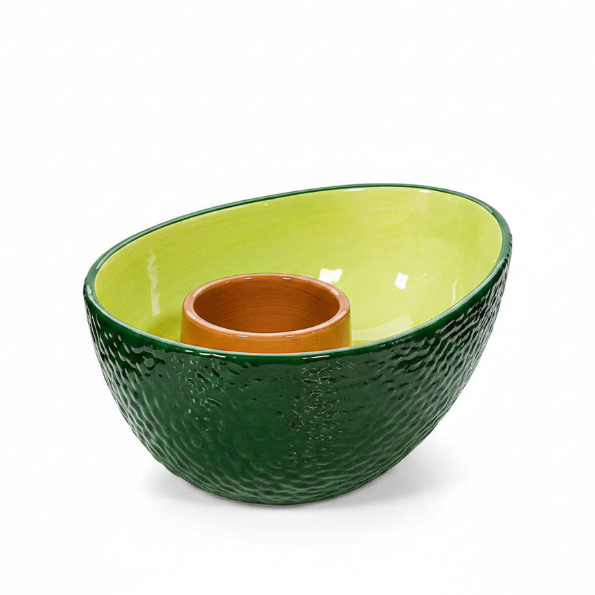 Green ceramic avocado-shaped chip and dip bowl with brown pit centre on white background