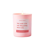 Pink candle with a humorous label on a light pink background