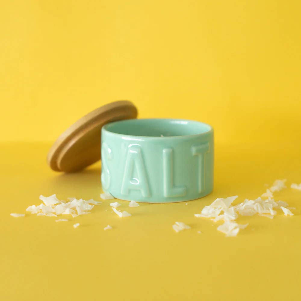 Turquoise ceramic salt cellar with bamboo lid and embossed SALT, styled on yellow