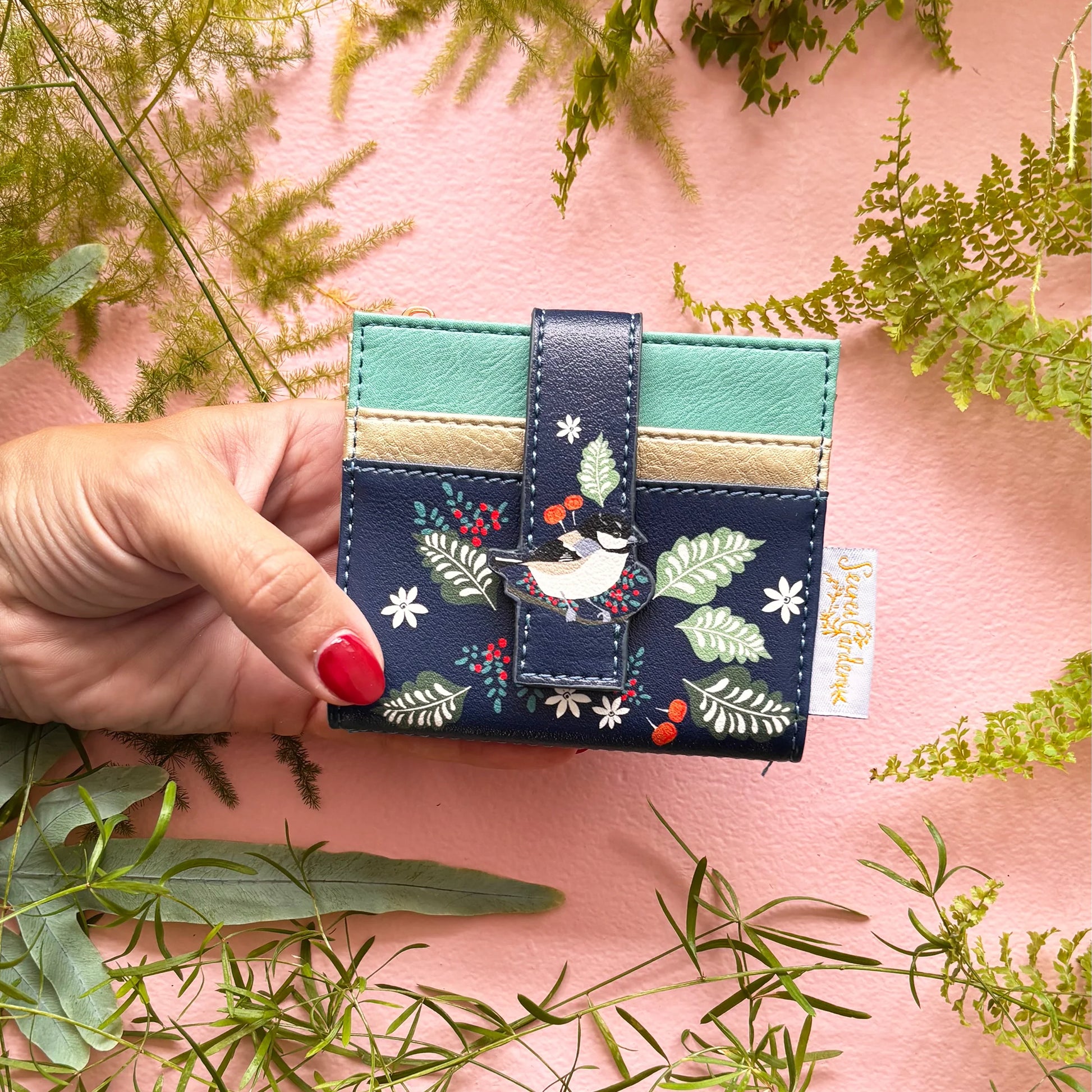 Bird purse held in hand showing compact size