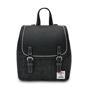 Black herringbone Harris Tweed Mini Jura backpack with black leather flap on white background.