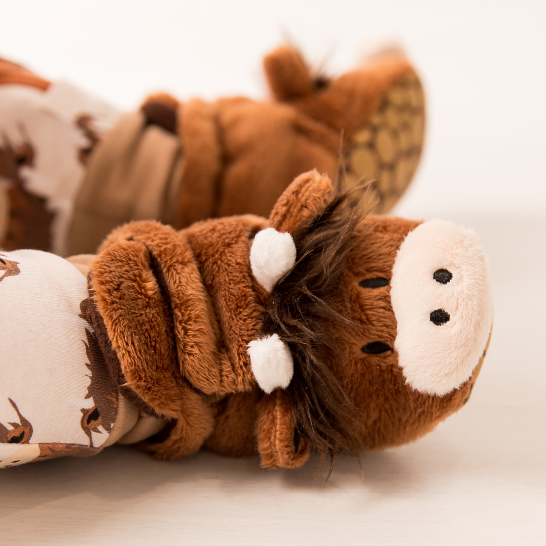 Pair of brown fleece highland cow booties on white background
