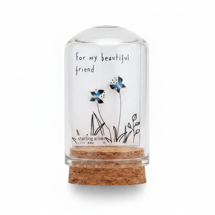 Small jewelry box with butterfly earrings and a personalized message on a textured surface.