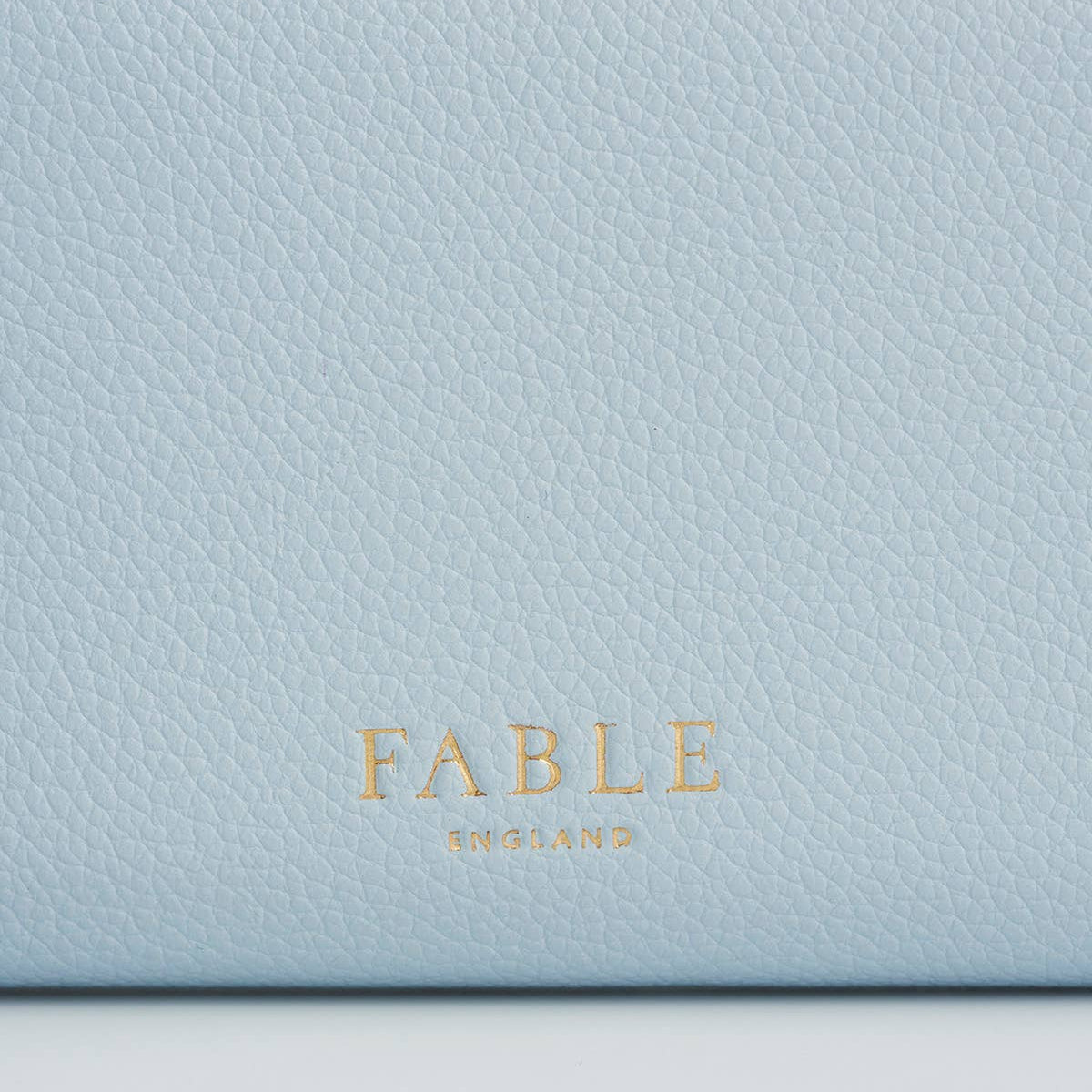 Back view of the light blue purse with Fable England logo.
