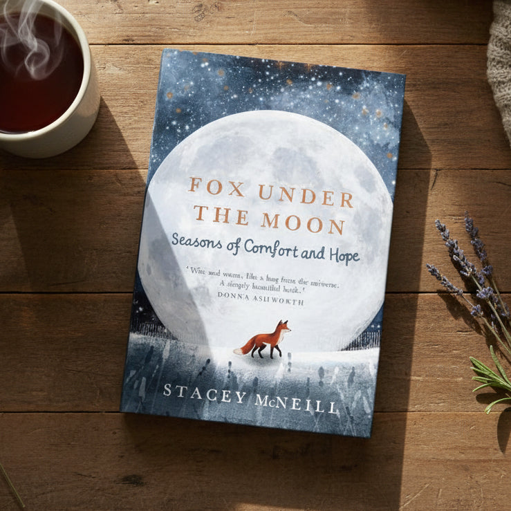 Fox Under the Moon book lying on a wooden table beside tea and lavender