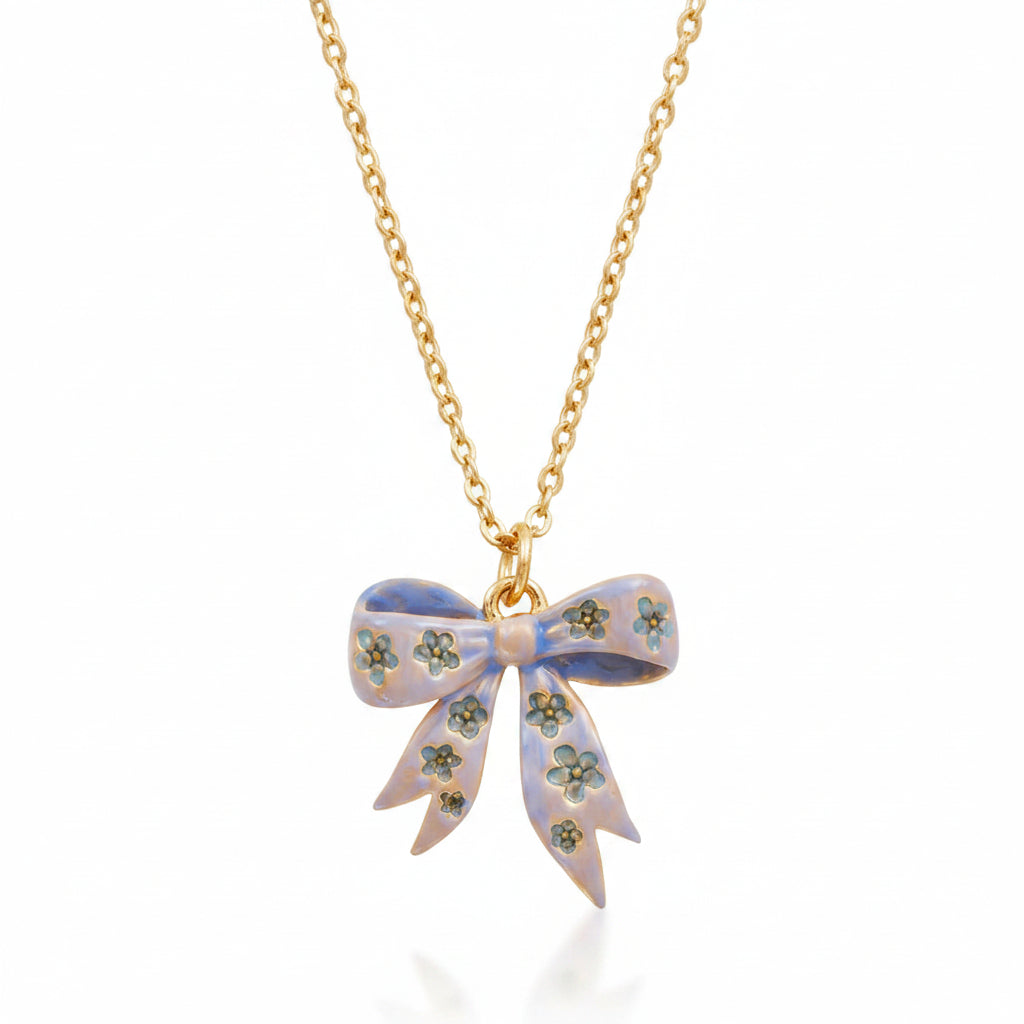 Close-up of enamel bow pendant with floral detail.