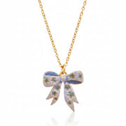 Close-up of enamel bow pendant with floral detail.