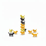 Hand stacking black and yellow cat pieces into a tall tower for Catastrophe game.