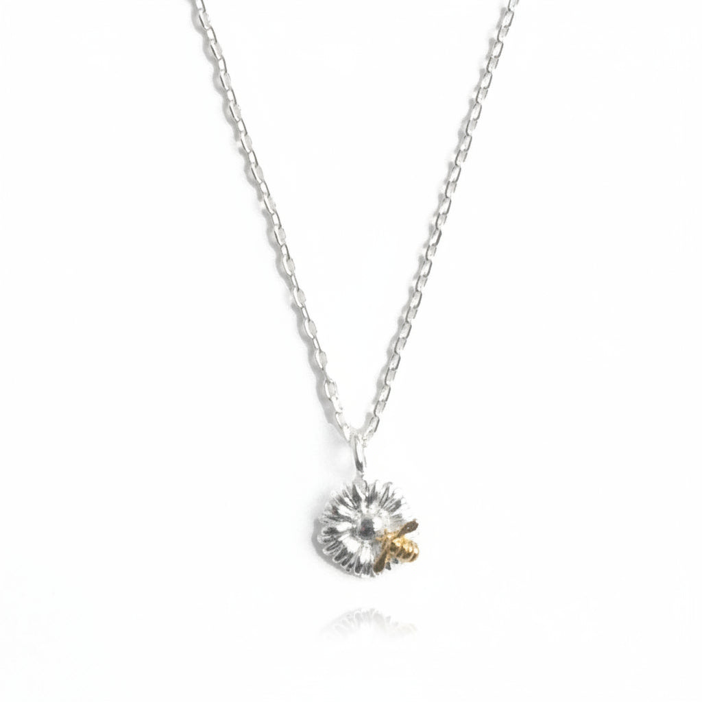 Close-up of bee and flower detail on two-tone pendant