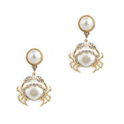 Gold crab drop earrings with pearlised resin and crystals on white background.